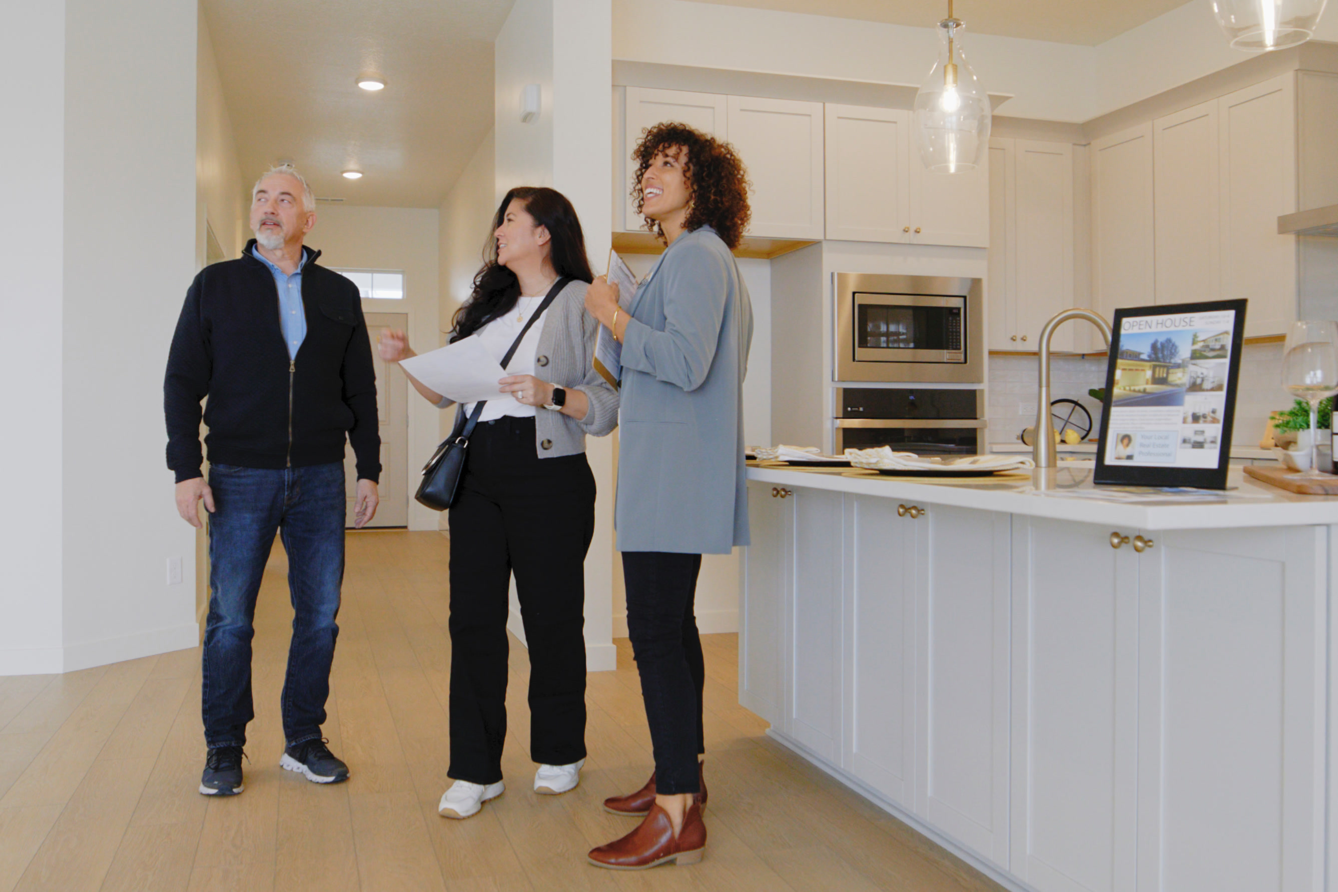 Inspector walking clients through a bright empty home interior