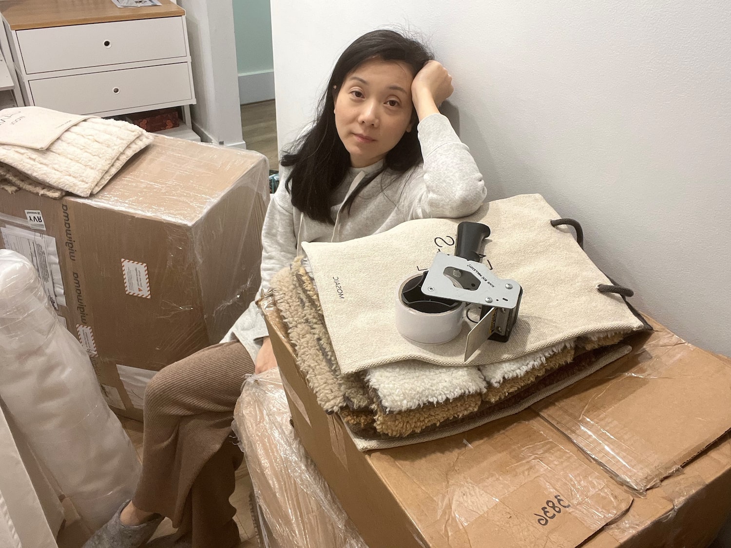 Sandy Wong personally packing rug shipments from her Vancouver apartment